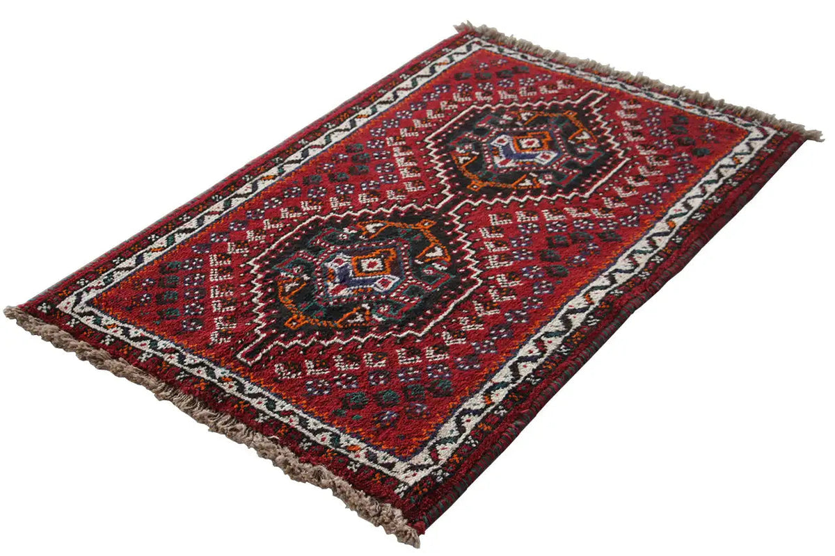 Oriental rug with a red border pattern and fringes, rectangular, photographed diagonally