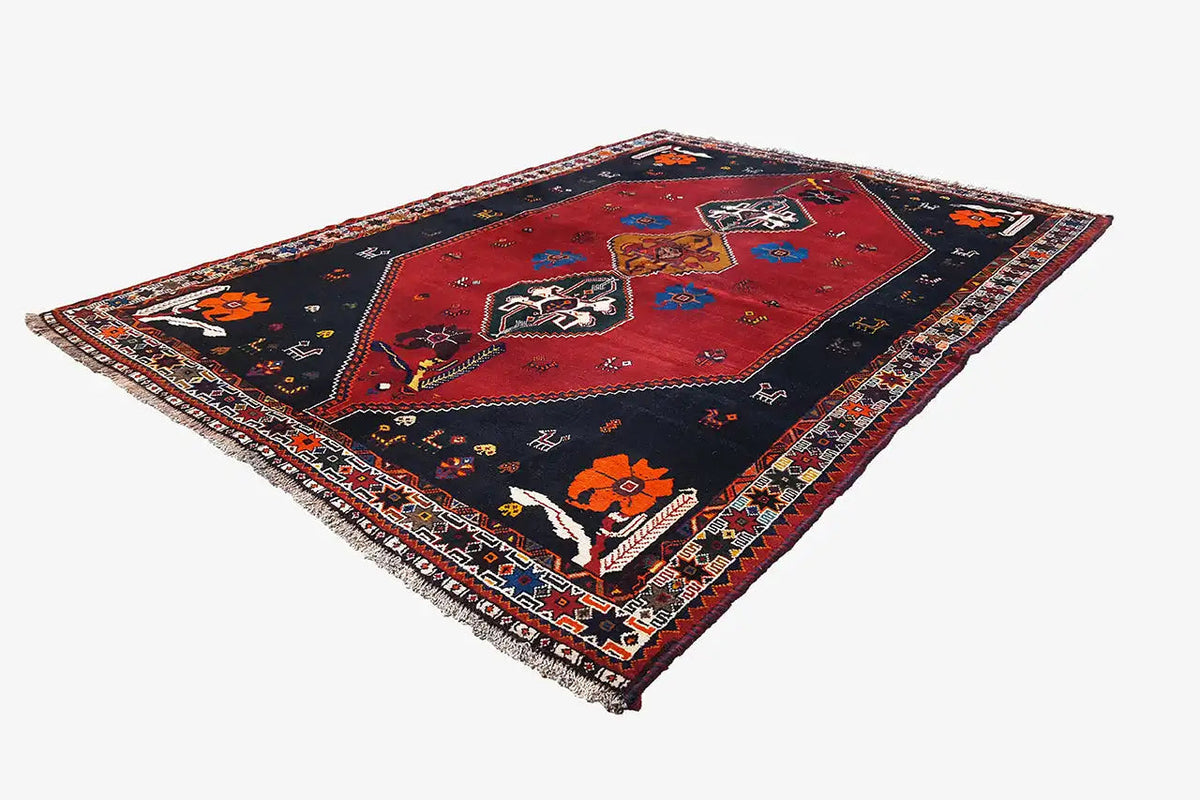 Oriental rug in dark blue and red with diamond medallions and a decorative border band