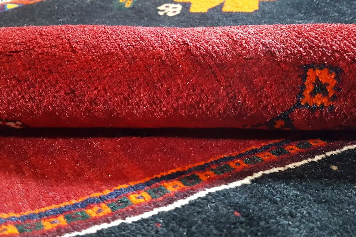 Close-up: red carpet pile with dark patterned elements and blue edging