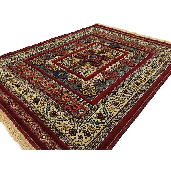 Rug with a diagonal border, cream-colored background, red accents, and fringe