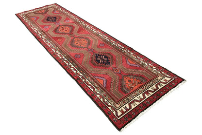 Hamadan runner with a red geometric design and decorative border, photographed at a slight angle