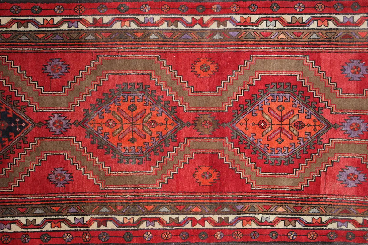 Close-up of the Hamadan runner: red ground with star-shaped medallions and repeating patterns