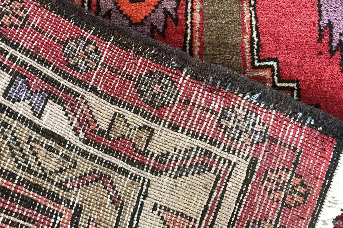 Hamadan runner detail at the selvage: multicolored zigzag patterns and visible fringes