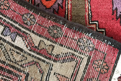 Hamadan runner detail at the selvage: multicolored zigzag patterns and visible fringes