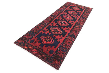 Red runner rug with a blue medallion and diamond pattern, with a fringed edge.