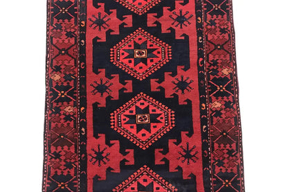Runner rug with a dark blue field and red geometric medallions, clear decorative borders.