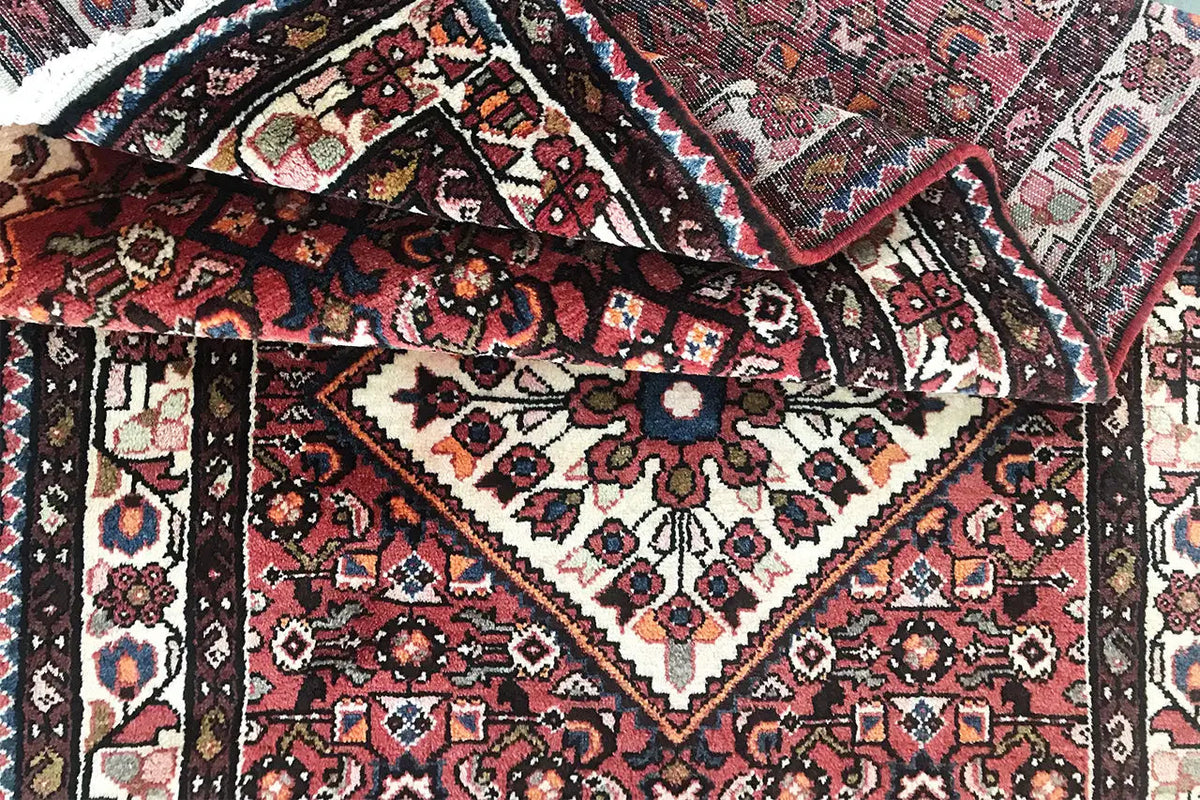 Hamadan runner pattern detail with diagonal borders and a central floral diamond