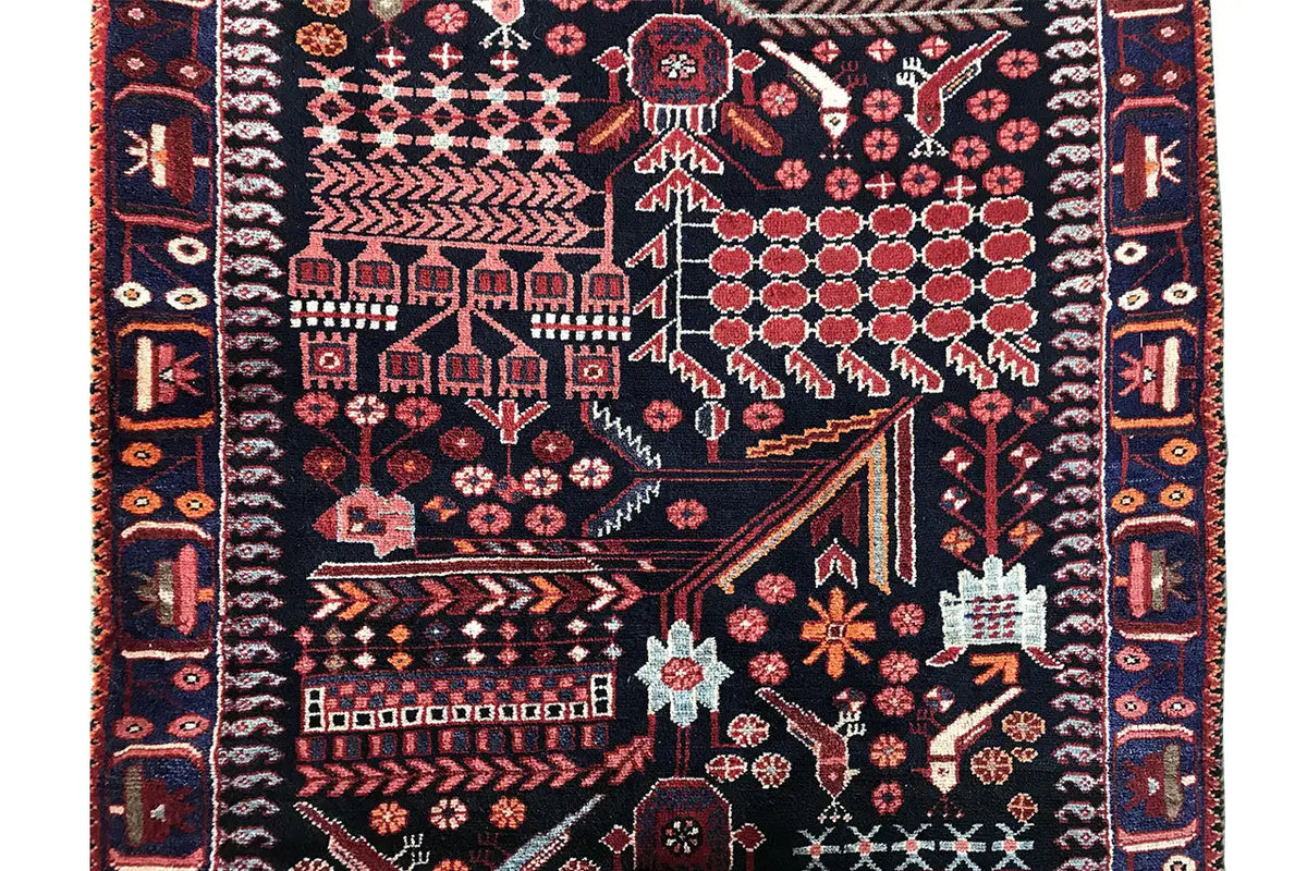Close-up of a runner rug: dark base pattern with red floral and vine ornamentation