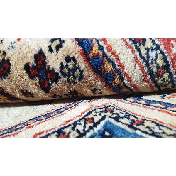 Rug edge with a light beige background and woven pattern, finished with short fringes