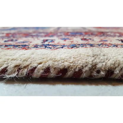 Close-up: beige carpet fringe and dense pile with colorful ornaments
