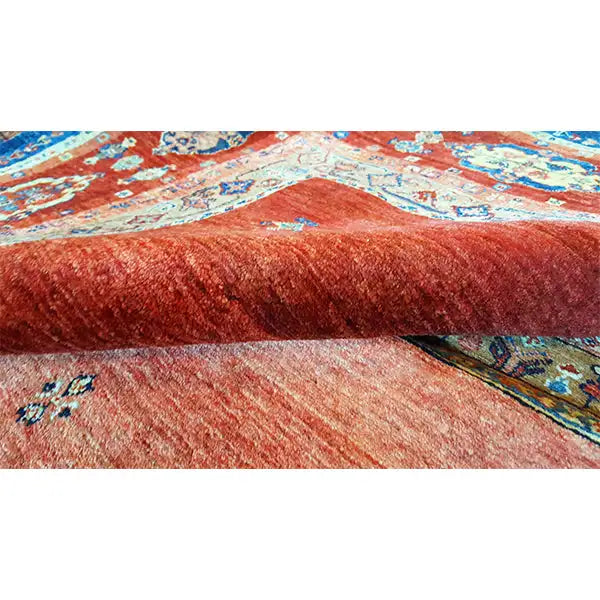 Close-up: carpet pile with a red, mottled surface and blue-red patterned areas