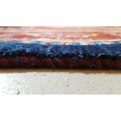 Rug cross-section: dark pile at the edge, with a multilayer carpet structure underneath