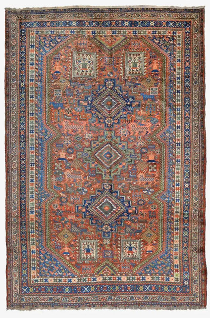 Rectangular Oriental rug with a patterned central motif in blue and rust red
