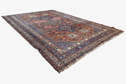 Oriental rug with a blue-brown border pattern and fringes, laid flat