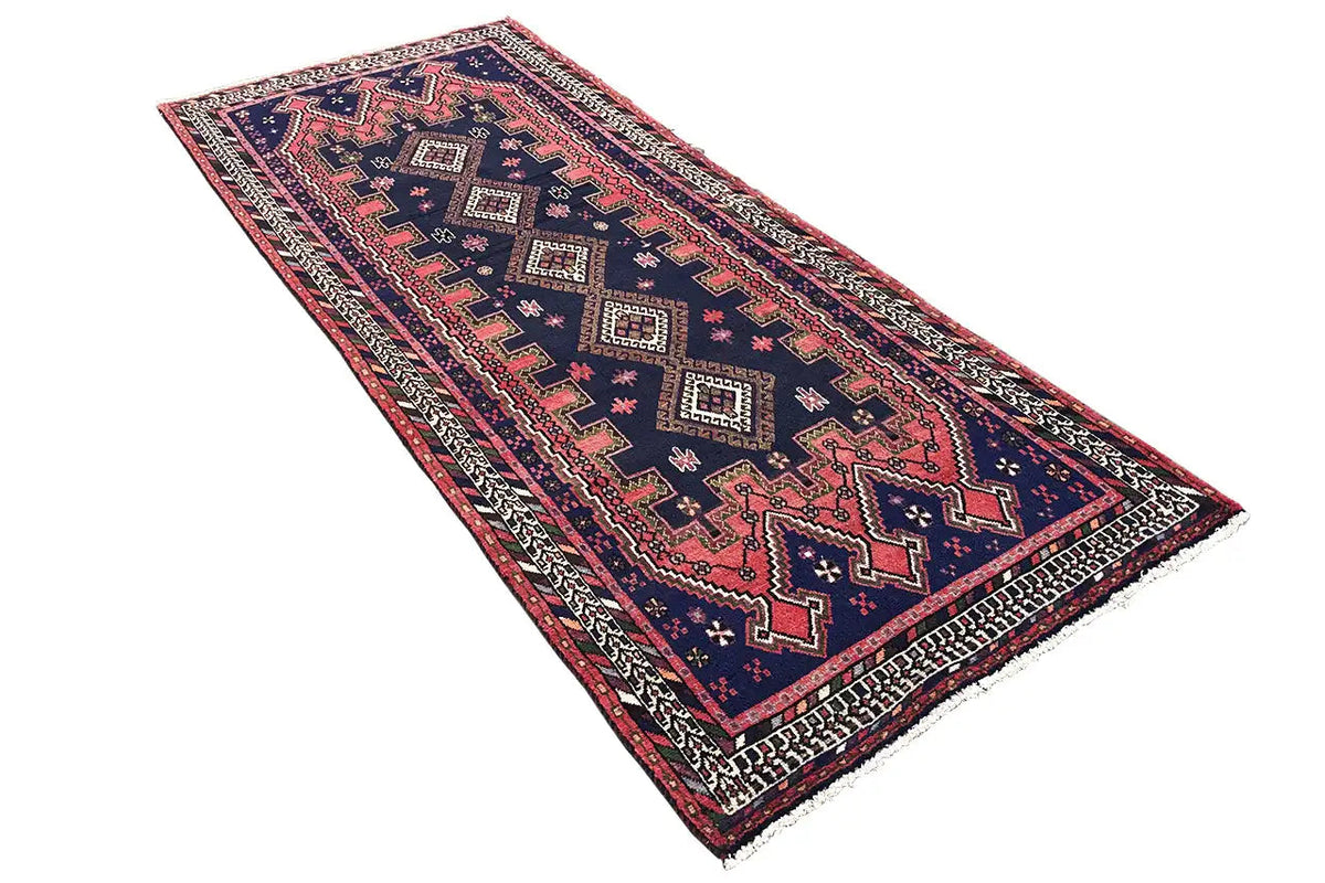 Sirjan runner: rectangular rug with a geometric border pattern in dark blue, red, and beige