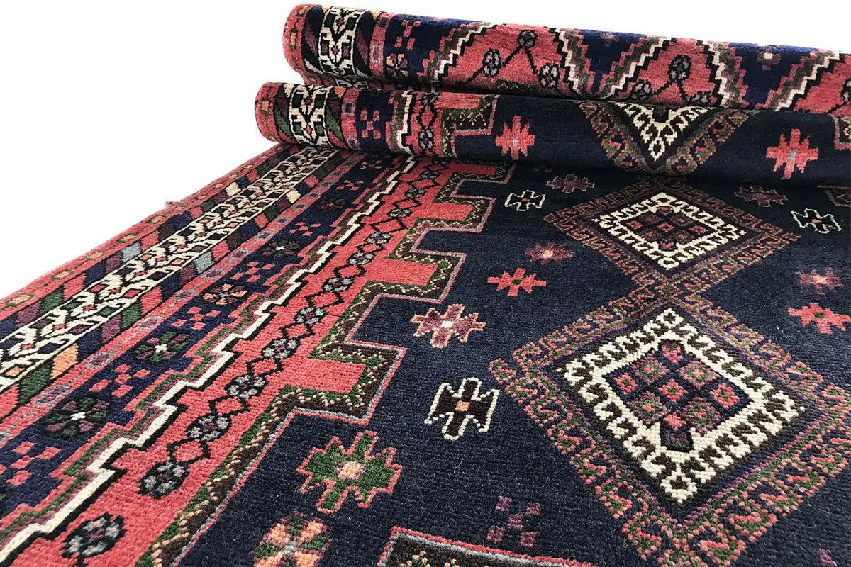 Rolled Sirjan runner: dark blue carpet with red ornaments and a distinctive border