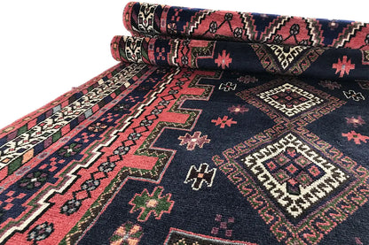 Rolled Sirjan runner: dark blue carpet with red ornaments and a distinctive border