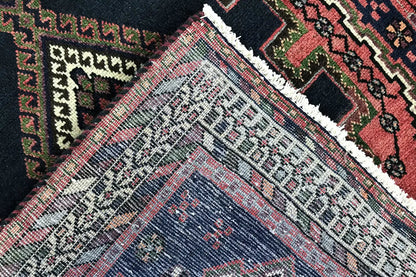 Close-up of Sirjan runner: patterned area with dark blue, red and green, as well as a white border