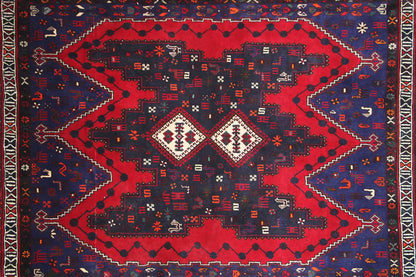 Rug surface with a large red central motif and geometric patterns in blue