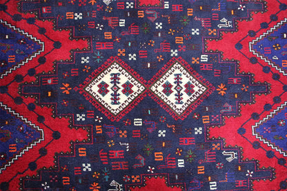 Close-up of a carpet pattern with diamonds and lines in red, blue, and white