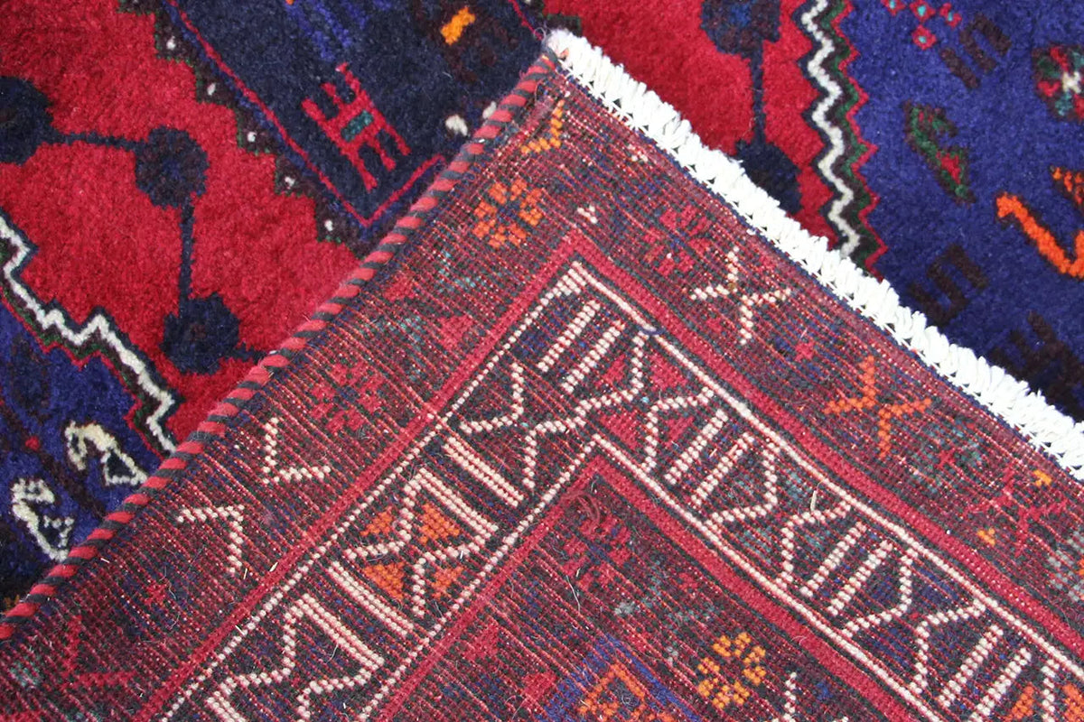 Detailed view: carpet fabric with a red and blue pattern and a white border