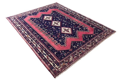 Oriental rug in a diagonal view: dark blue, vivid red, and fine borders