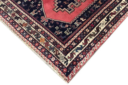 Oriental rug corner with fringe: dark blue, red, and cream-colored decorative lines