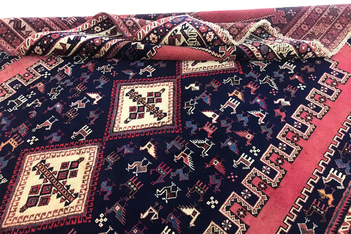 Close-up of an oriental rug: dark blue pattern, red areas, and cream-colored motifs