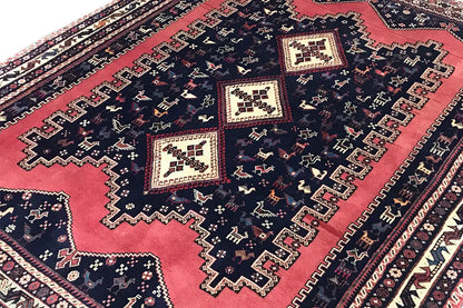 Oriental rug detail view: dark blue with red areas and ornamental border bands