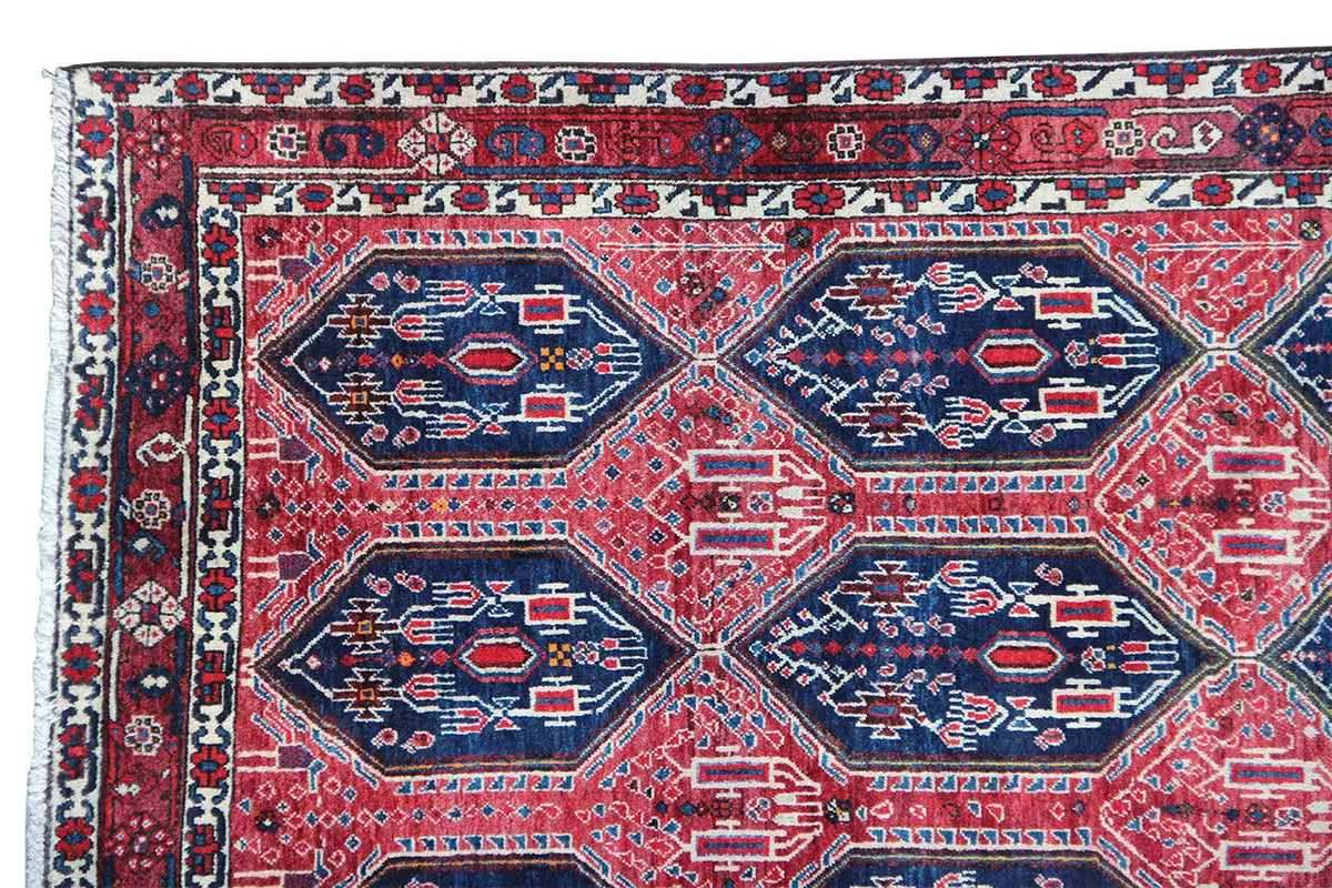 Oriental rug with a red background and a geometric pattern in blue and white