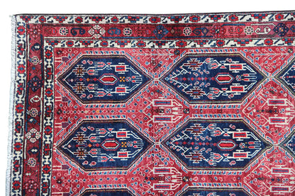 Oriental rug with a red background and a geometric pattern in blue and white