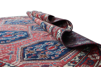 Rolled oriental rug, red and blue pattern with a dark pile backing