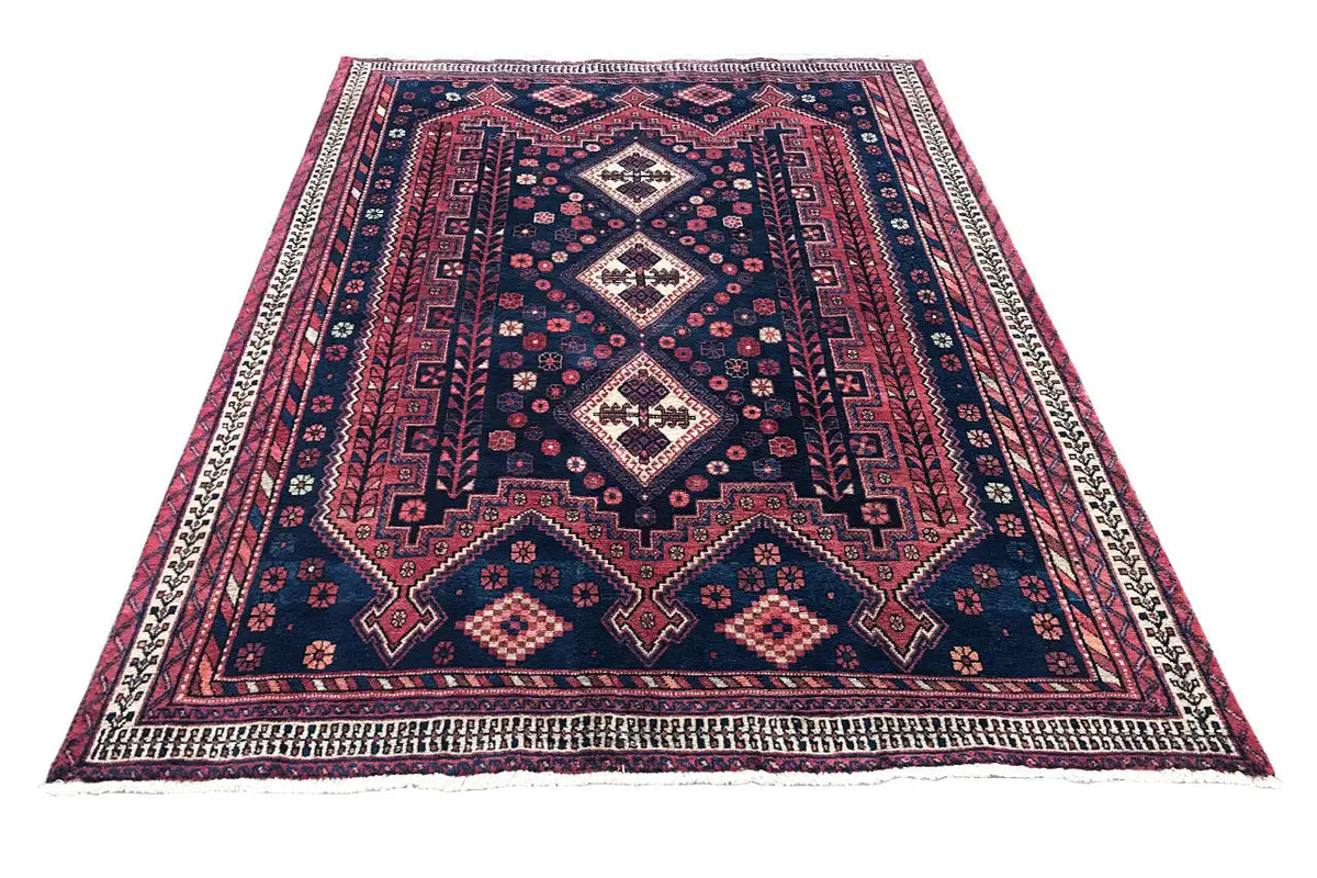Rug with a geometric diamond pattern in dark blue, red and white, with a border all around