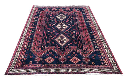 Rug with a geometric diamond pattern in dark blue, red and white, with a border all around