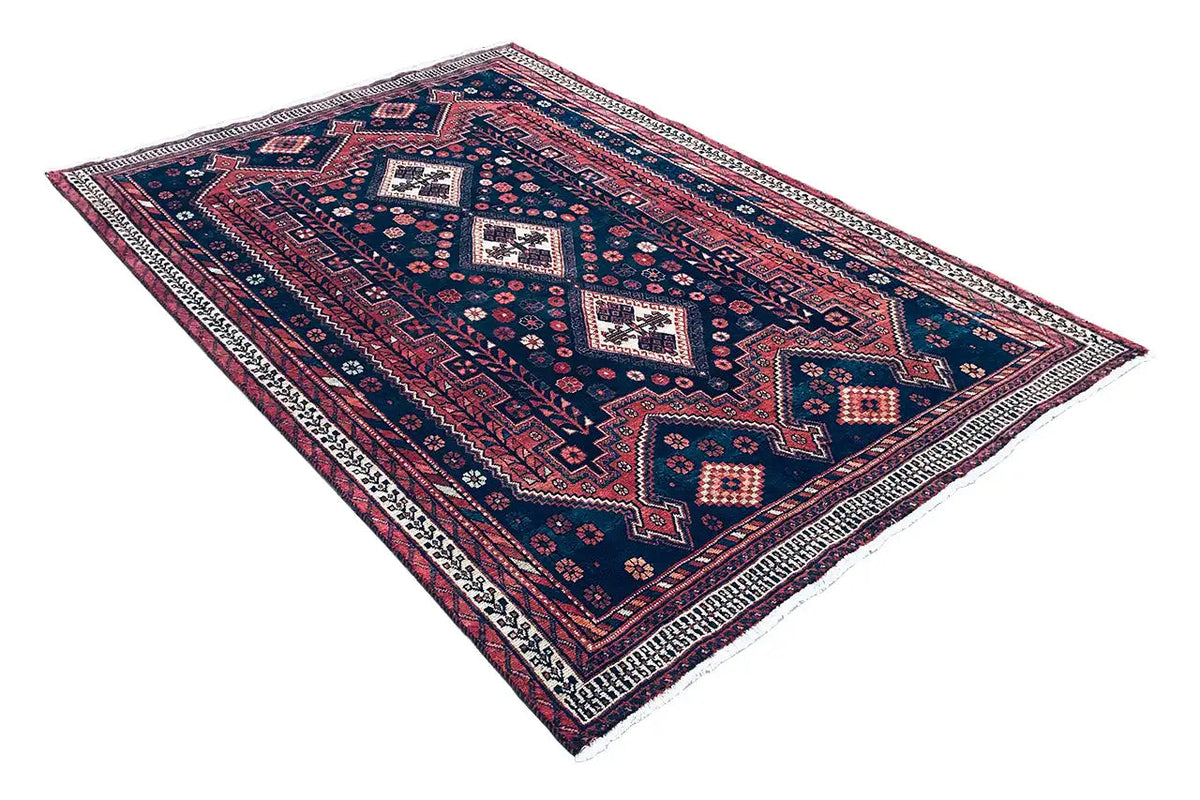 Rug with geometric patterns in dark blue and red, white ornaments, a clean border frame