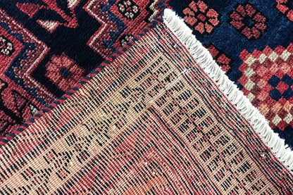 Carpet detail with a dense weave, red-and-white patterns, and a bound edge