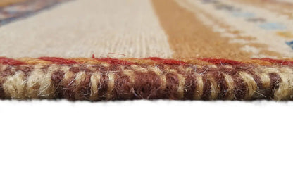 Rug edge with a twisted border seam, colorful woven texture, and tassel fringe.