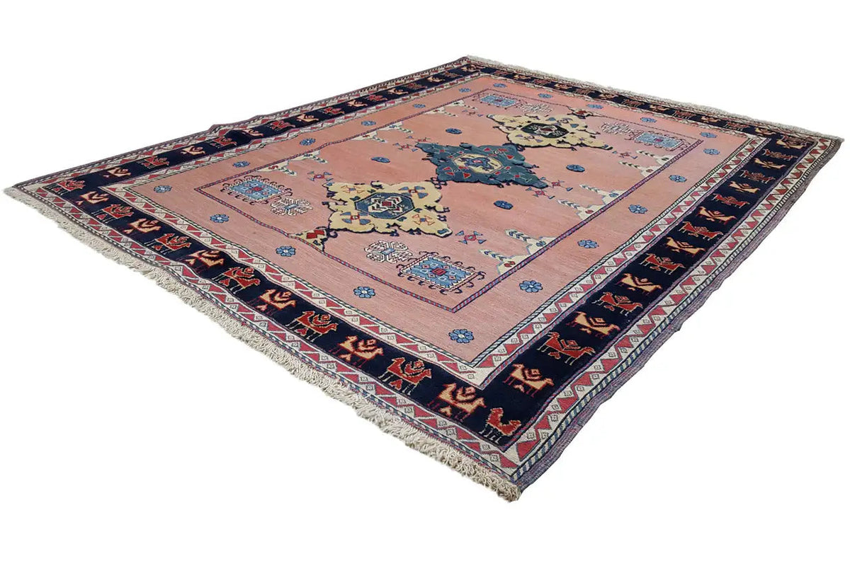 Oriental rug with a geometric medallion design in pink, blue, and dark blue, border