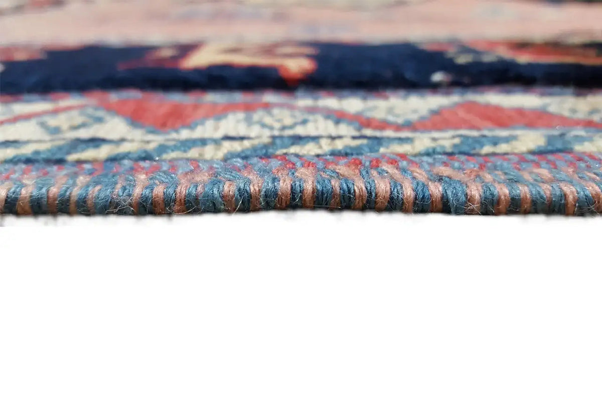 Close-up of the carpet edge with a multicolored border pattern and fringes