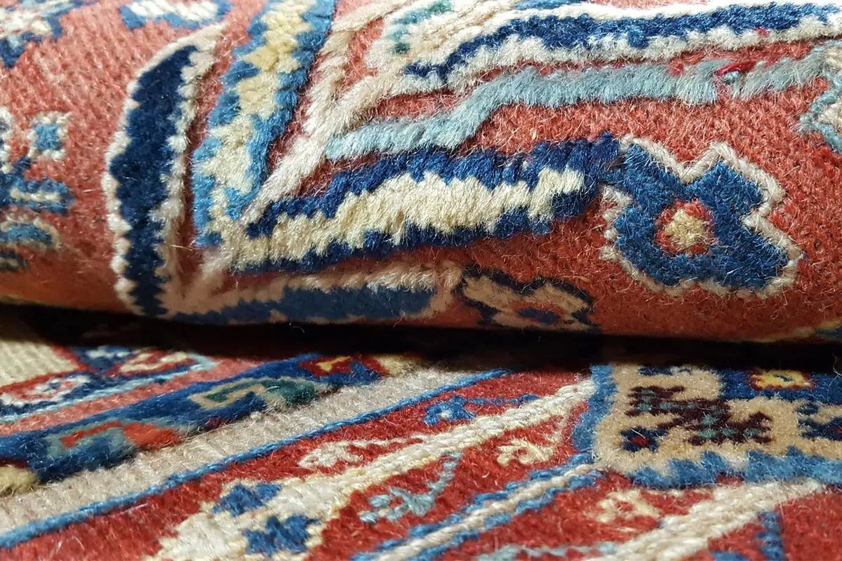 Soumak rug: close-up view with a blue patterned stripe on a red background