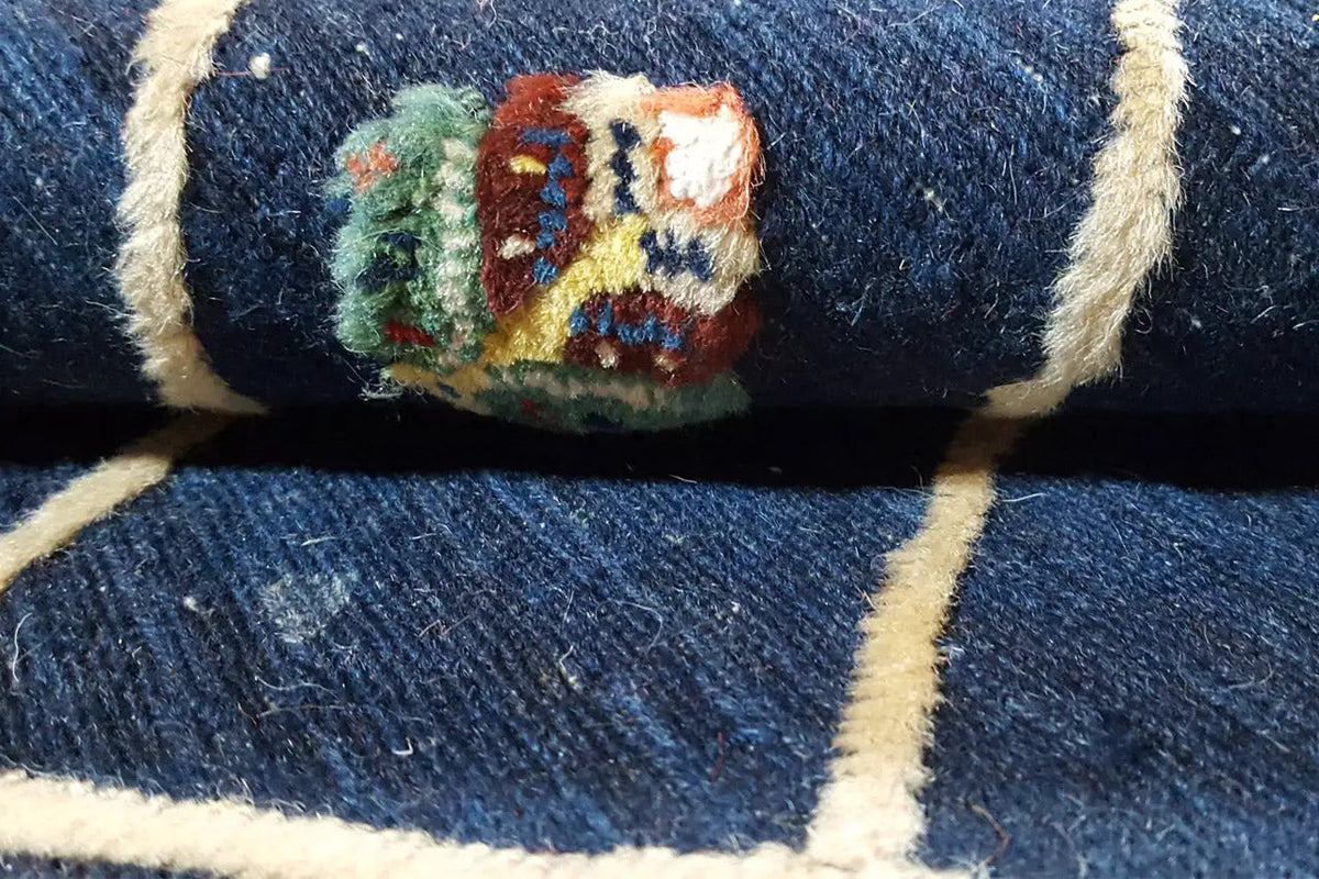 Close-up of rug: dark blue background with a multicolored medallion pattern