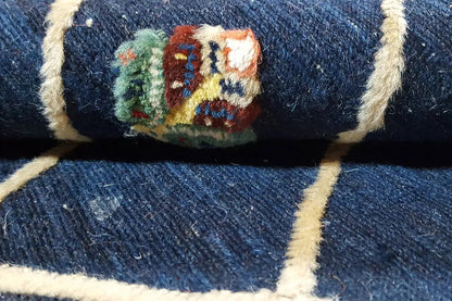 Close-up of rug: dark blue background with a multicolored medallion pattern