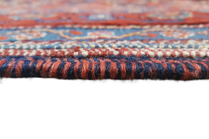 Rug edge with a dense woven border, reddish fibers and blue decorative trim
