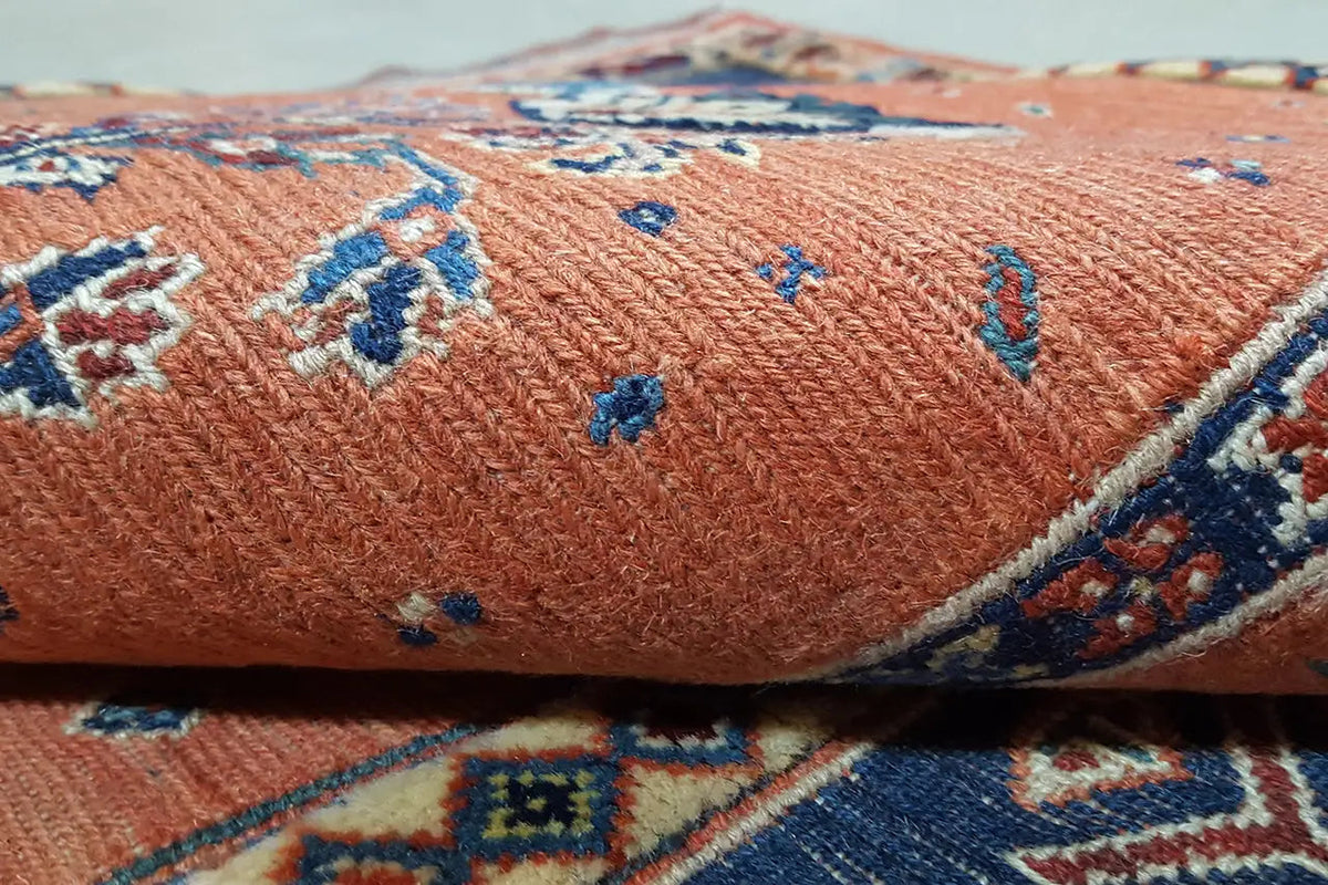 Soumak rug detail: orange pile surface with blue decorative pattern