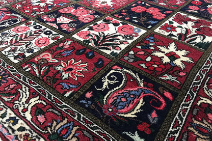 Oriental rug with geometric border panels and floral patterns in red and dark blue