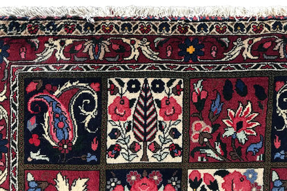 Close-up of an Oriental rug: border stripes and floral motifs in red and blue