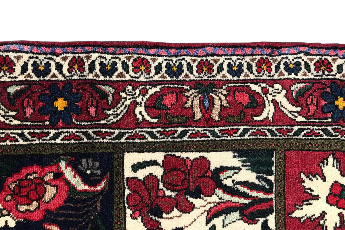 Strip view of an Oriental rug with vine ornaments and flowers in red, blue, and cream