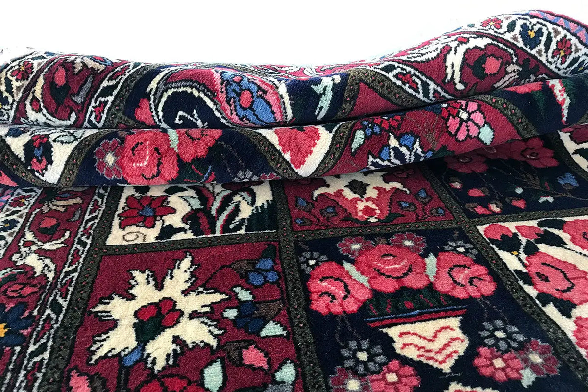 Folded Oriental rug with colorful square mosaic motifs and a dark border