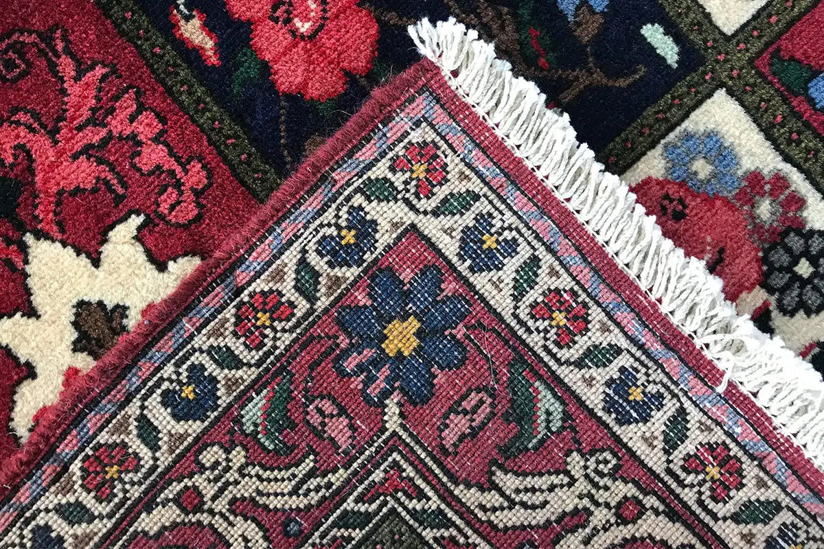 Oriental rug corner with fringed threads and a diamond pattern in red, blue, and beige