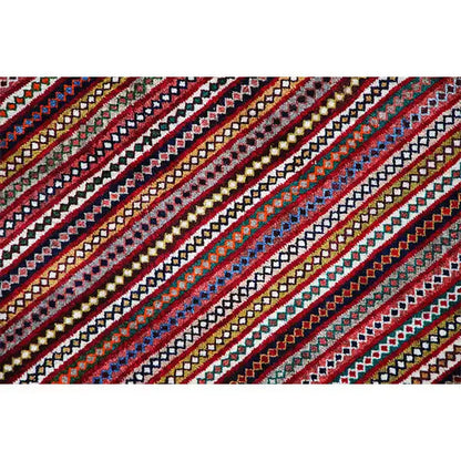 Close-up of a Gabbeh rug: diagonal stripes in red, blue, green, and yellow with an ornamental border